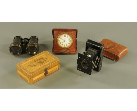 An ostrich cased travelling clock by Benson, a folding camera, straw box, pair of binoculars and a carved wooden page turner.