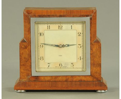 An Art Deco period walnut mantle clock, the square dial with eight day movement supported upon squat chromium feet.  Width 19