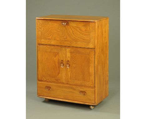 An Ercol light elm bureau, the rectangular top with rounded corners above the fall front with fitted interior above two cupbo