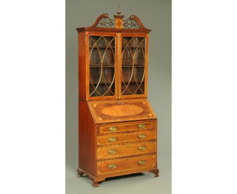 A 19th century mahogany and inlaid bureau bookcase, having a swans neck and fretwork pediment with central urn finial above t