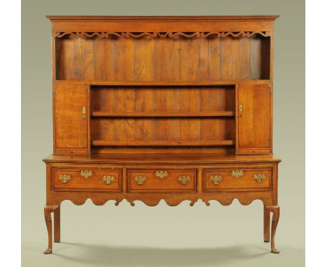 An 18th century Queen Anne style oak and mahogany crossbanded dresser with rack, with moulded cornice above a series of open 