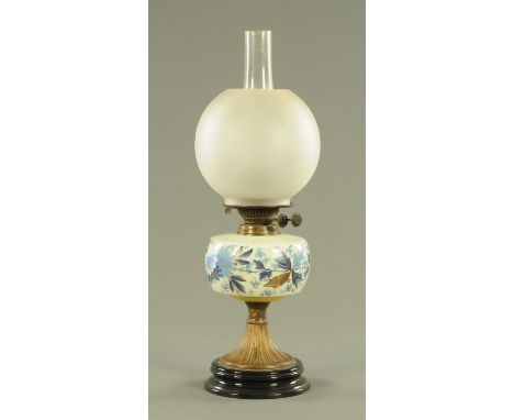 A Victorian oil lamp, having a frosted glass spherical shade and opaline glass reservoir, hand painted with flowers all upon 
