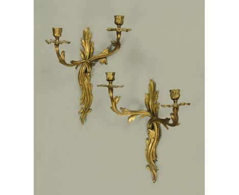 A pair of brass two branch wall light fittings, in the rococo style.  Height +/- 40 cm, width 30 cm. 