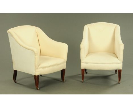 A pair of Edwardian armchairs, upholstered in cream cotton material and raised on tapered front legs terminating in castors. 