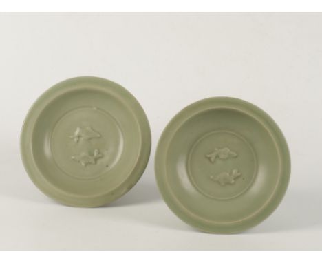 A MATCHED PAIR OF CHINESE CELADON TWIN FISH BOWLS, Song Dynasty, each with flat rim and crisply moulded fish, of light sea gr