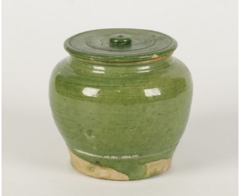 A CHINESE APPLE GREEN GLAZED JAR AND LID, probably Tang, with ovoid body, the flat lid with button knop,12cm high.Condition r