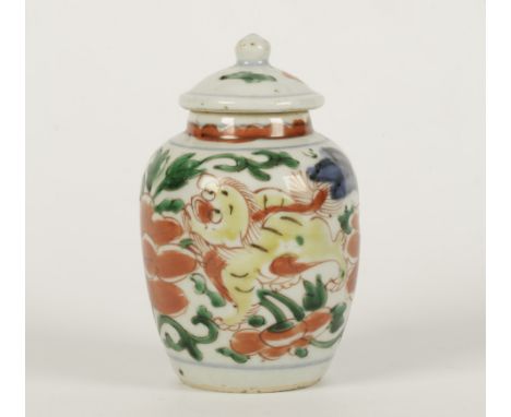 A CHINESE POLYCHROME DECORATED PORCELAIN JAR AND COVER, 17th century, the ovoid body painted with lively fo-dogs amongst huge