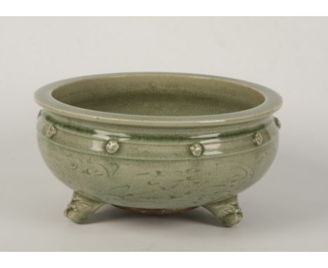 A CHINESE CELADON TRIPOD CENSER, Ming, with circular, flat rim over beaded studs incised with foliate motifs upon dragon mask