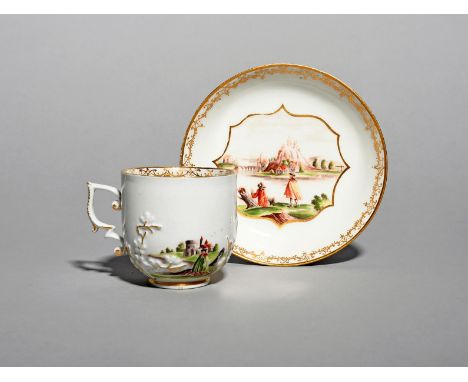 A Meissen Hausmaler cup and saucer, c.1740, applied with three sprigs of flowering prunus and painted probably in the worksho