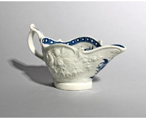 A Worcester blue and white sauceboat, c.1770, the exterior boldly moulded with large sprays of rose and other flowers, the in