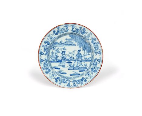 A delftware plate, c.1760, painted with two Chinese figures standing beneath a fringed tree in a garden landscape, a pagoda v