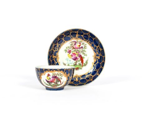 A rare Worcester teabowl and saucer, c.1765, painted with colourful fancy birds perched in and beneath leafy branches, reserv