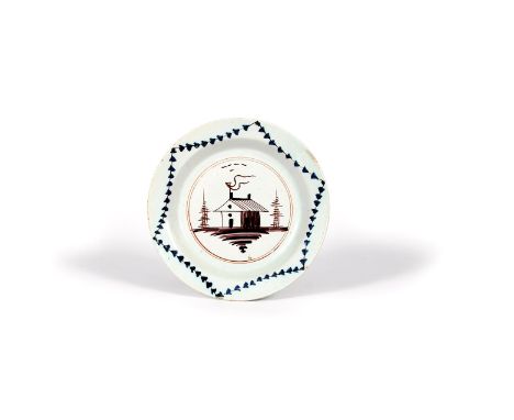 A delftware plate, c.1750, probably London, painted in manganese, red and blue with a small hut flying a long pennant, within