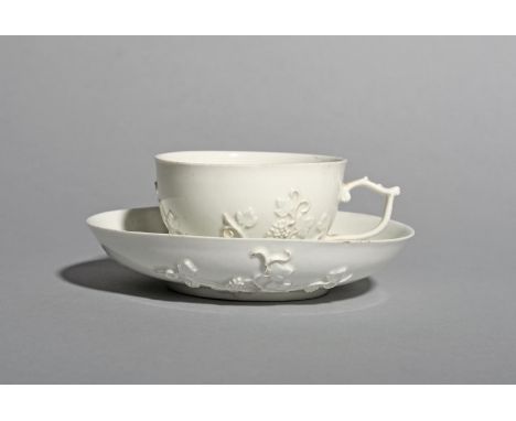 A Meissen teacup and saucer, c.1730, left in the white and applied with sprigs of fruiting grapevine, the cup with a delicate