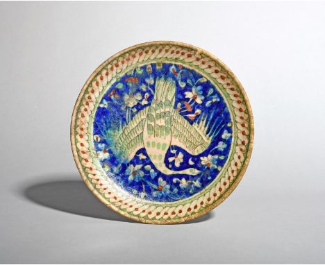 An Islamic pottery dish, 19th century or earlier, painted in the Iznik manner with a central bird with outstretched wings res