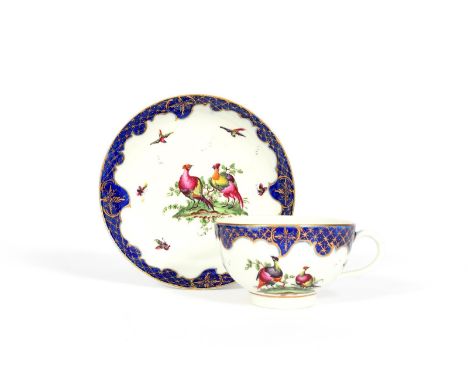 A Worcester teacup and saucer, c.1770, painted with small exotic birds in flight around larger colourful birds before leafy b