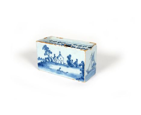 A delftware flower brick, c.1760, the rectangular form painted to the long sides with a figure in a boat beside trees and bui