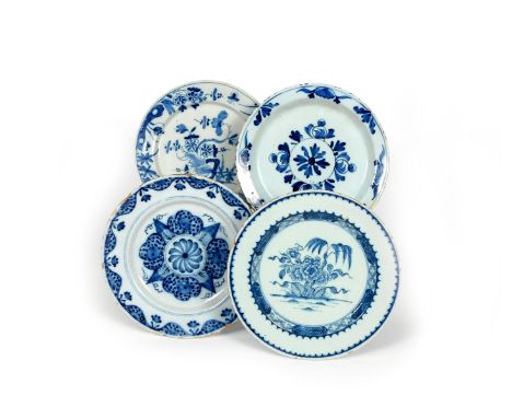 Four delftware plates, c.1740-60, two painted in blue with differing designs of flowering Oriental plants, two with geometric