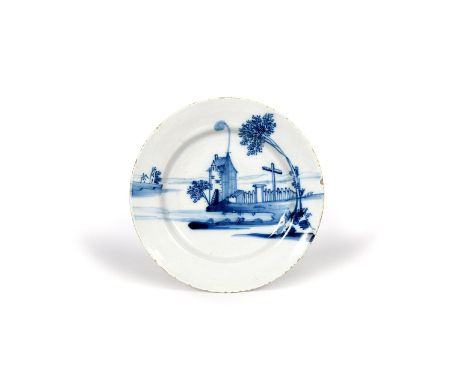 A delftware plate, mid 18th century, probably Bristol, painted in blue with a tall house at the water's edge, issuing smoke f