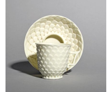 A Saint Cloud white-glazed coffee cup and trembleuse saucer, c.1730-40, moulded in the artichoke manner with bands of overlap