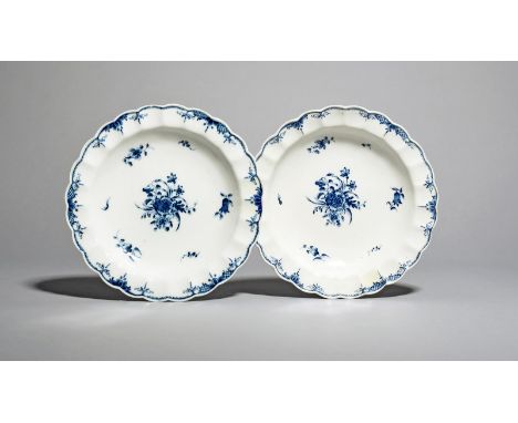 A rare near pair of Caughley blue and white plates,  c.1785-92, painted with the Salopian Peony spray, within smaller scatter