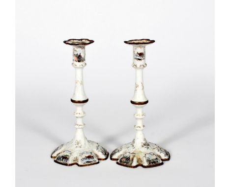 A small pair of Staffordshire enamel candlesticks, c.1770, the hexagonal feet printed and coloured with scenes of figures on 