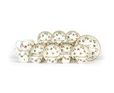 A Bristol part tea service, c.1770, the fluted forms painted with garlands of polychrome flowers suspended from gilt rings be