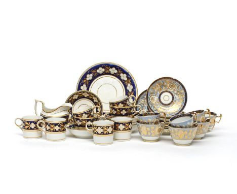 Two English porcelain part tea services, c.1800-20, decorated with formal floral designs in gilt and white on differing blue 
