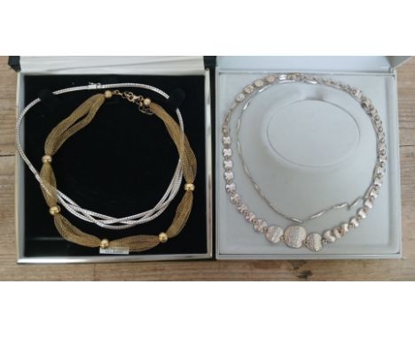 A group of four silver choker necklaces.