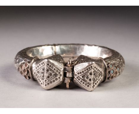 A LARGE SILVER COLOURED METAL TORQUE BANGLE, having repousse and etched decoration throughout, originally with turquoise high