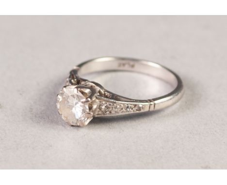 PLATINUM RING WITH A ROUND BRILLIANT CUT SOLITAIRE DIAMOND in eight claw setting, eight tiny diamonds to the shoulders, appro