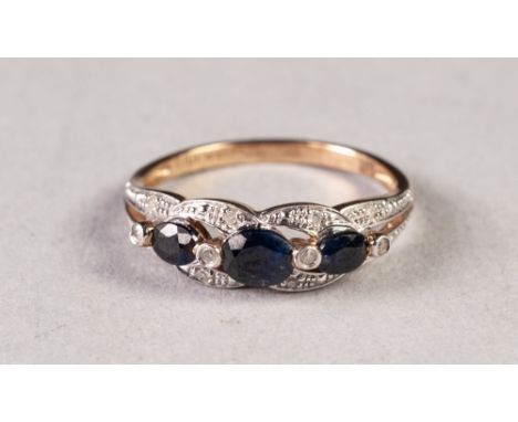 9ct GOLD, SAPPHIRE AND TINY DIAMOND RING, the open work setting having a row of three graduated oval sapphires and twelve tin