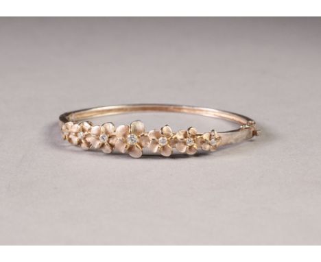 SILVER HINGED OPENING NARROW BANGLE, the top with seven pink enamelled flower heads, each set with a centre white stone and a