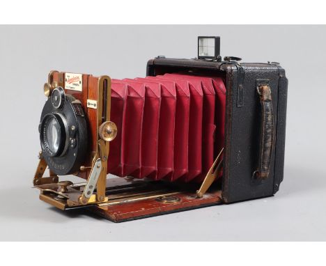 A Houghtons Sanderson Regular Quarter Plate Hand and Stand Camera, serial no 8953, circa 1904, chamfered red bellows, double 