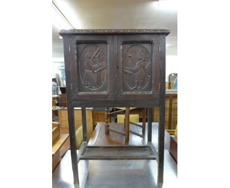 A small 19th Century oak two door cupboard, the doors carved with Galileo and Newtons Theory Of Light