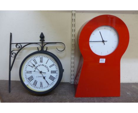 A red metal mantel clock and a reproduction Kensington clock