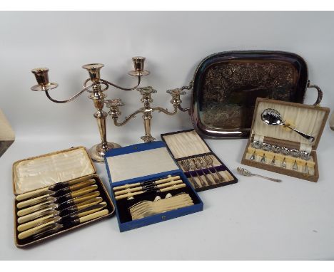 A quantity of plated ware to include twin handled tray, candelabra, cased flatware (fish knives and forks with mounts marked 