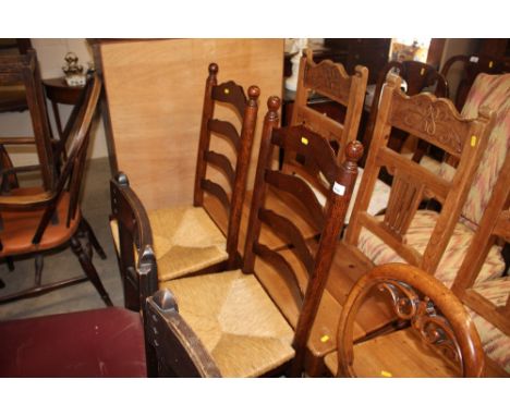 A pair of oak ladder back and rush seated dining chairs 