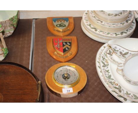 Two wooden crests; and a wooden cased barometer 