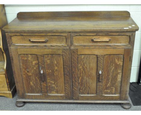 An Art Deco style oak sideboard, two drawers over two single door cupboards, 87cm x 123cm x 47cm