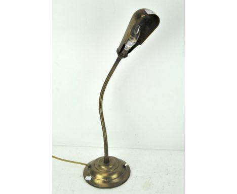 A vintage brass desk lamp of articulated form, with operation button to base