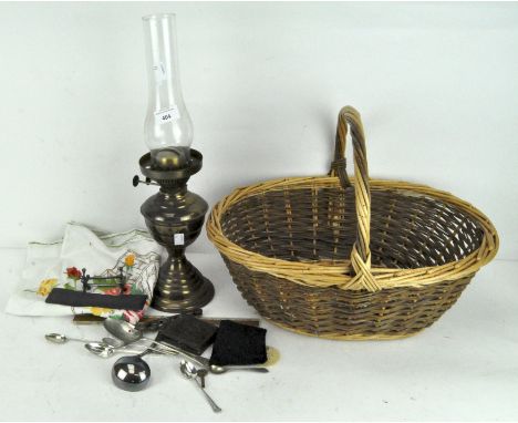 Assorted items, including an oil lamp, silver plate flatware, 19th century Daguerrotype and more, all in a wicker basket