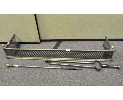 A pierced fire fender, 105cm wide, together with two fireside tools