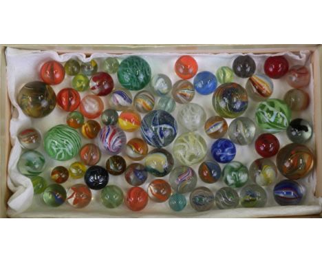 A collection of approximately 110 vintage marbles, including various German latticino swirls, contained within a card table-t