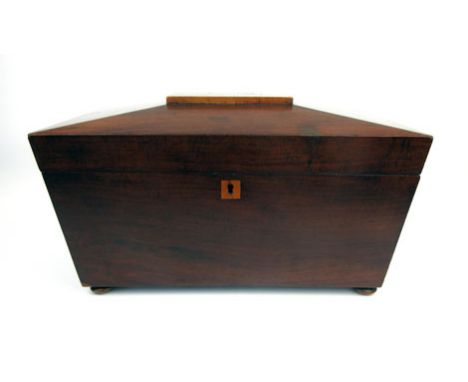An early 19th century sarcophagus mahogany tea caddy with two internal tea compartments on squat bun feet, h. 17 cm, w. 30 cm