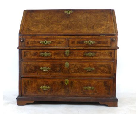 An early 18th century walnut herringbone line inlaid and crossbanded bureau, the fall front enclosing fitted interior with co