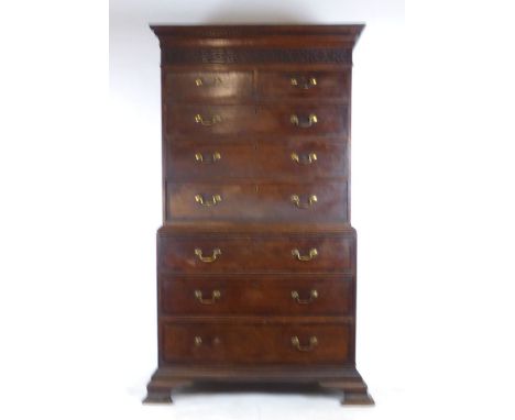 A mid 18th century oak chest on chest, the cornice over a blind fret panel and two short over three long drawers above three 