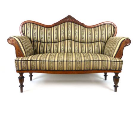 A 19th century walnut two seat sofa upholstered in striped silk fabric with shaped and carved top rail over carved arms and s