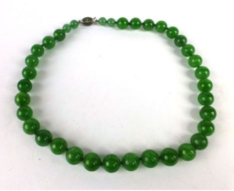 A single strand graduated green jade bead necklace, overall l. 40 cm