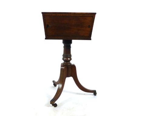 A Regency mahogany and ebony strung tea-poy, the swivel top with two rotating sides revealing two caddy compartments to one s